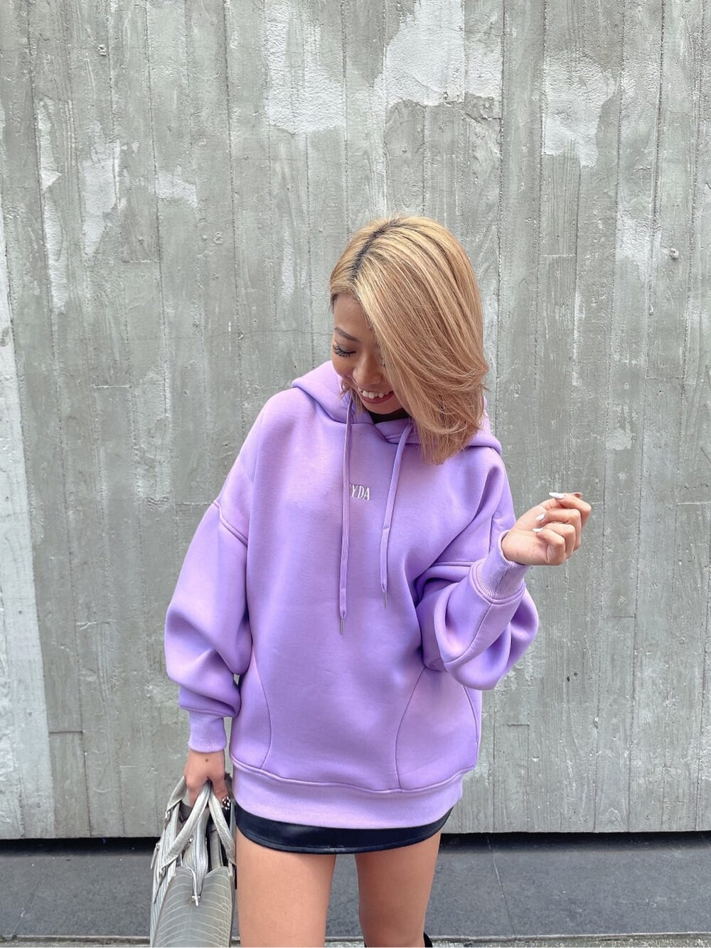 パープル系のTシャツ/カットソー、ブラック系のブーツ、ブラック系のスカートを着用したレディースの冬コーディネートの4枚目の写真