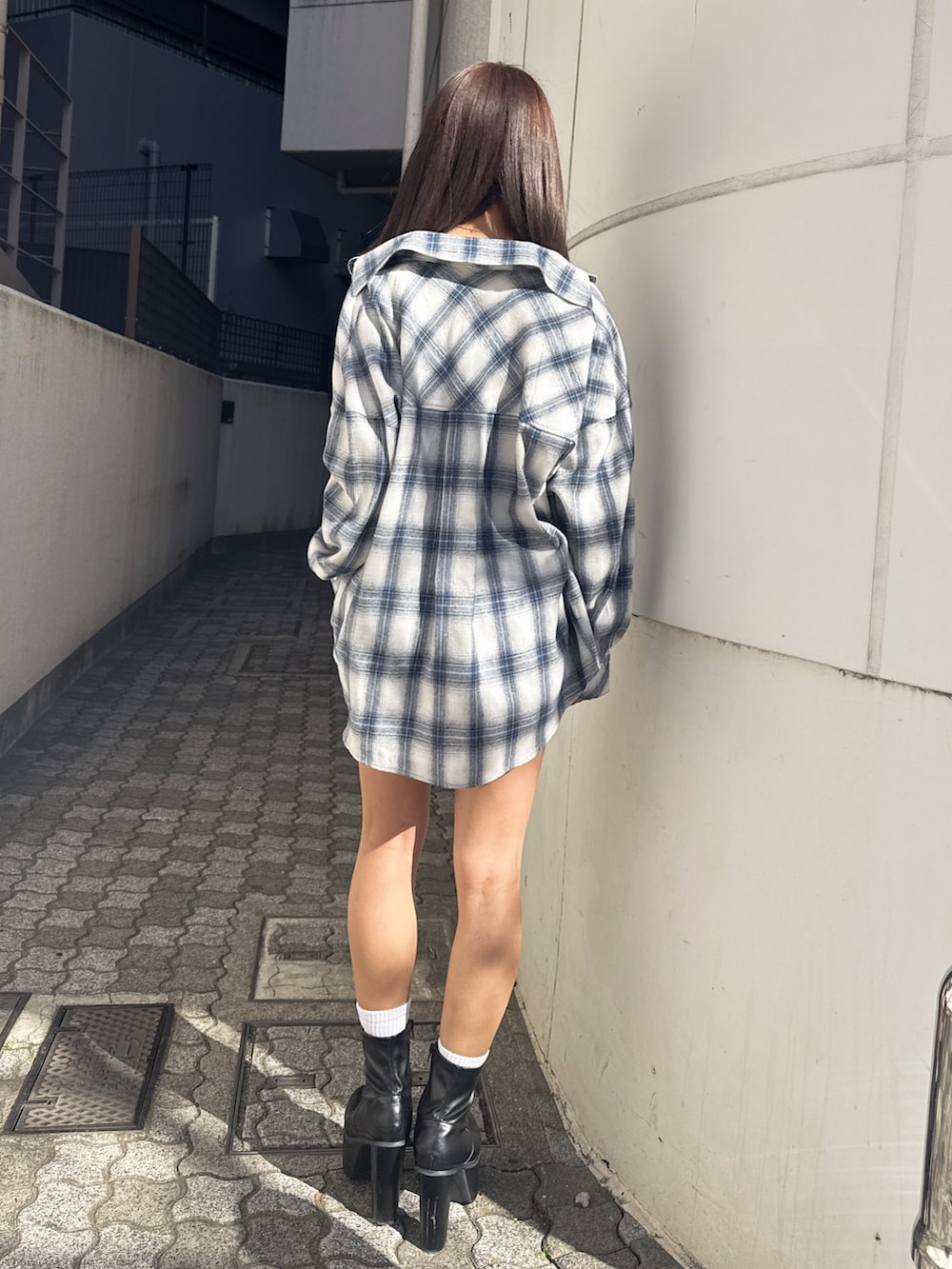 ホワイト系のTシャツ/カットソー、ブルー系のシャツ/ブラウス、ブラック系のデニムパンツを着用したレディースの春コーディネートの5枚目の写真