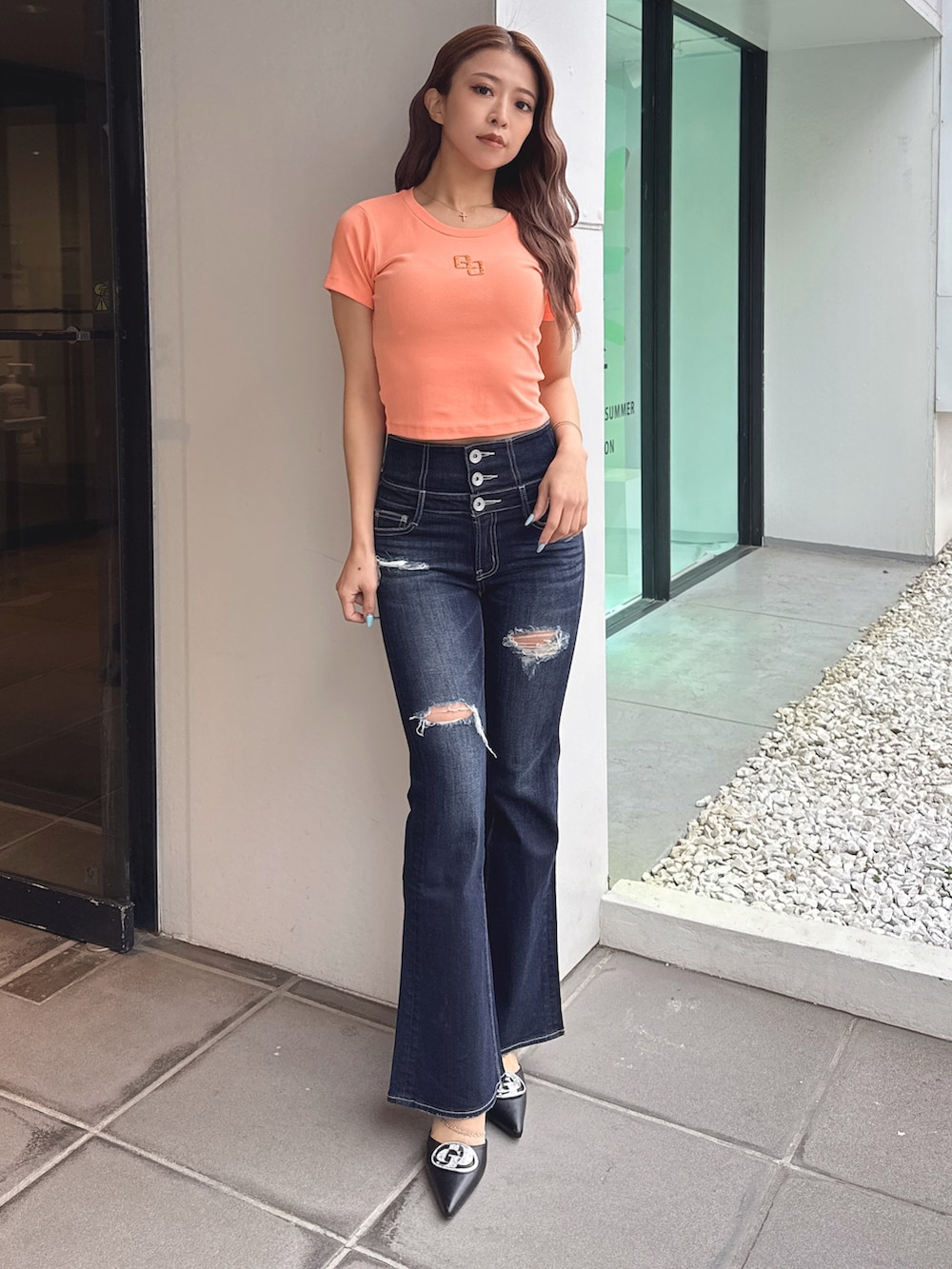 オレンジ系のTシャツ/カットソー、ブルー系のデニムパンツ、ブラック系のパンプスを着用したレディースの春コーディネートの2枚目の写真