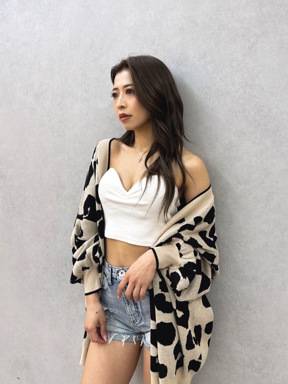 ホワイト系のチューブトップ、ベージュ系のカーディガン/ボレロ、ブルー系のデニムパンツを着用したレディースの夏コーディネートの5枚目の写真