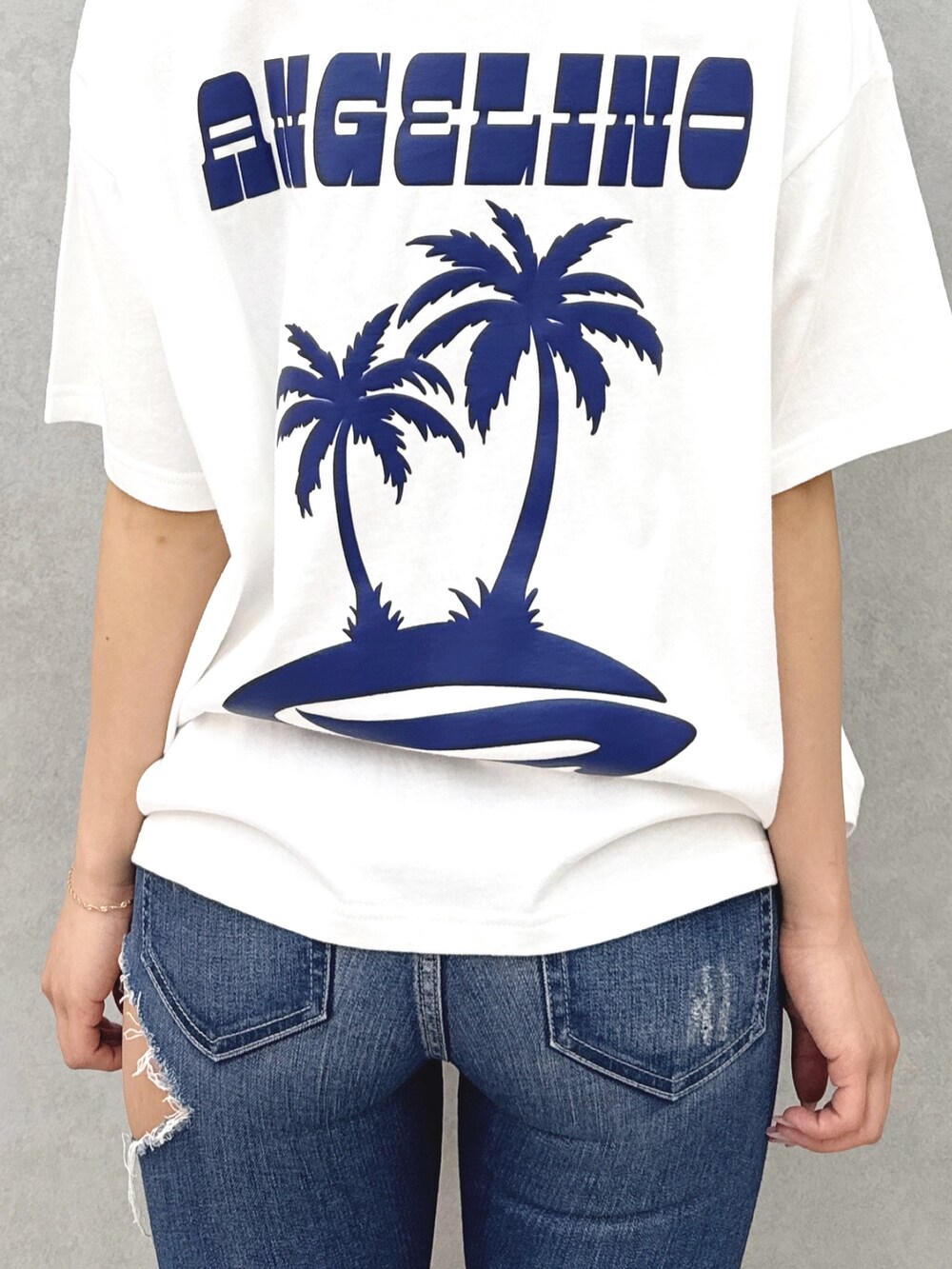 ホワイト系のTシャツ/カットソー、ブルー系のデニムパンツ、ホワイト系のパンプスを着用したレディースの春コーディネートの6枚目の写真