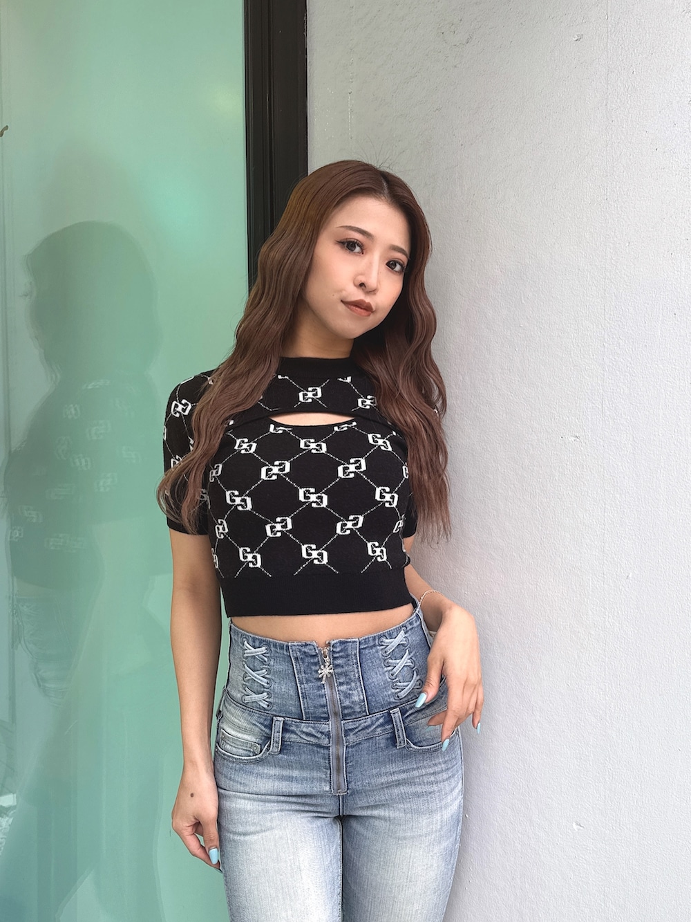 ブラック系のニット/セーター、ブルー系のデニムパンツ、ブラック系のパンプスを着用したレディースの春コーディネートの6枚目の写真