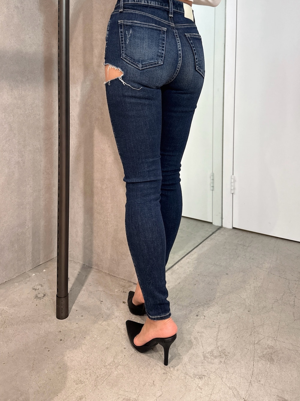 ホワイト系のTシャツ/カットソー、ブラウン系のダウンジャケット/コート、ブルー系のデニムパンツを着用したレディースの秋コーディネートの9枚目の写真