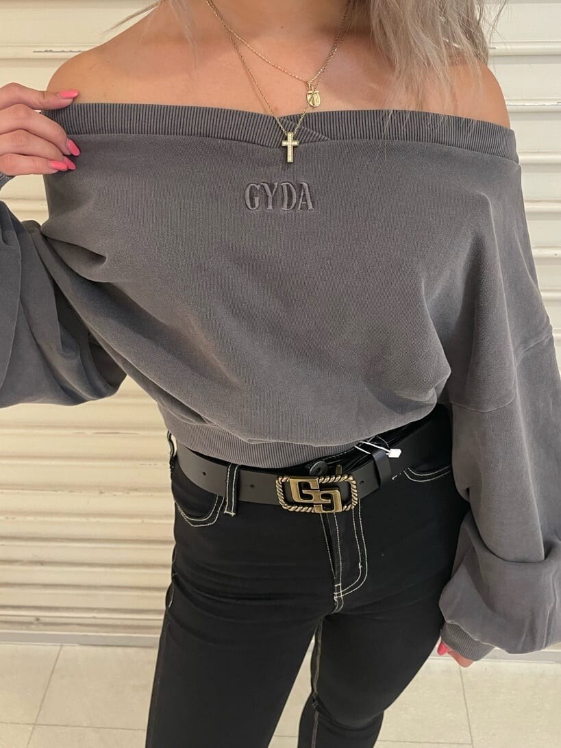 ブラック系のデニムパンツ、グレー系のスウェット、ブラック系のブーツを着用したレディースの秋コーディネートの5枚目の写真