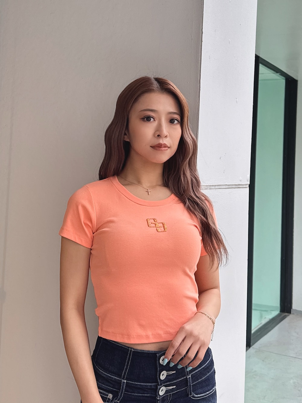 オレンジ系のTシャツ/カットソー、ブルー系のデニムパンツ、ブラック系のパンプスを着用したレディースの春コーディネートの5枚目の写真