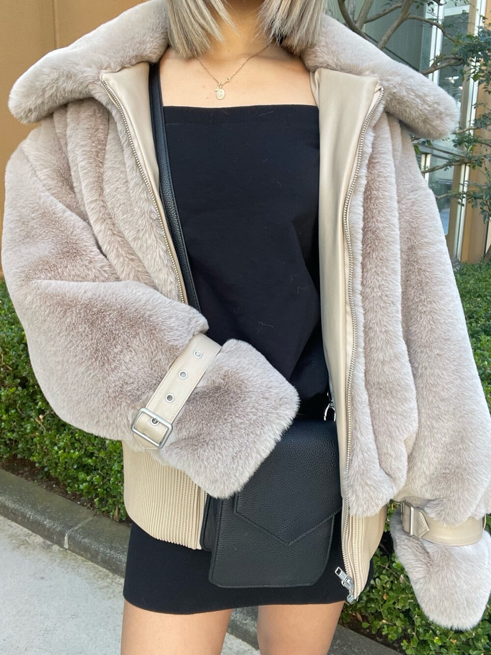 ベージュ系のブルゾン、ブラック系のワンピース、ブラック系のブーツを着用したレディースの冬コーディネートの6枚目の写真