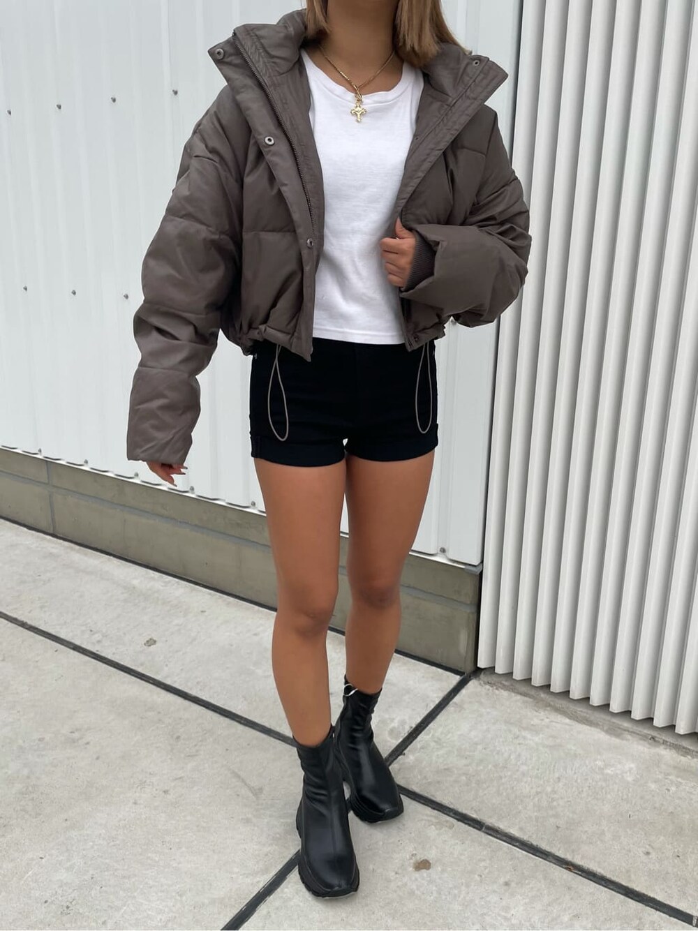 ベージュ系のダウンジャケット/コート、ブラック系のデニムパンツ、ブラック系のブーツを着用したレディースの秋コーディネートの4枚目の写真