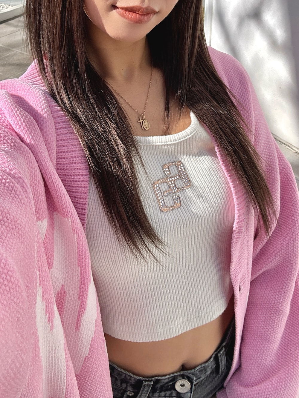 ホワイト系のTシャツ/カットソー、ピンク系のカーディガン/ボレロ、ブラック系のデニムパンツを着用したレディースの春コーディネートの6枚目の写真