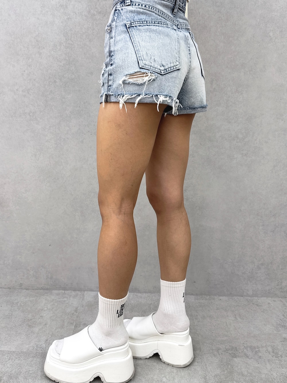 ホワイト系のチューブトップ、ベージュ系のカーディガン/ボレロ、ブルー系のデニムパンツを着用したレディースの夏コーディネートの8枚目の写真