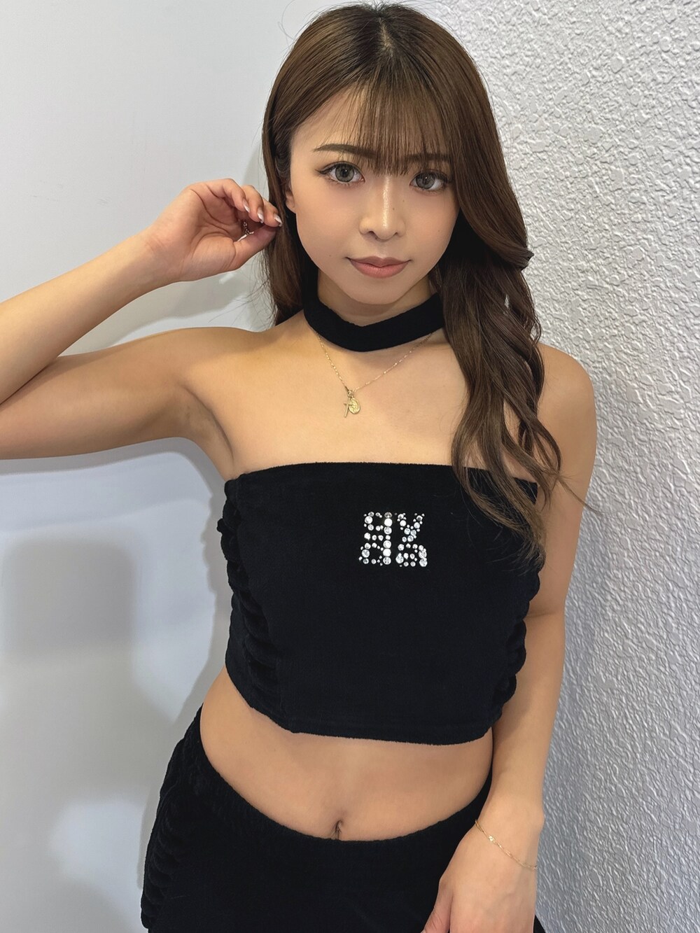 ブラック系のチューブトップ、ブラック系のその他パンツ、ホワイト系のパンプスを着用したレディースの春コーディネートの6枚目の写真