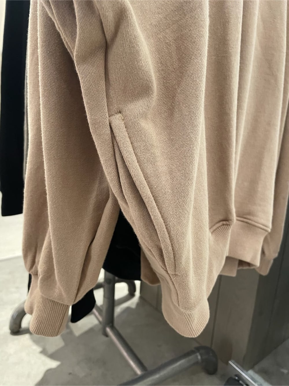 ブラック系のブーツ、ベージュ系のパーカー、ゴールド系のネックレスを着用したレディースの秋コーディネートの6枚目の写真