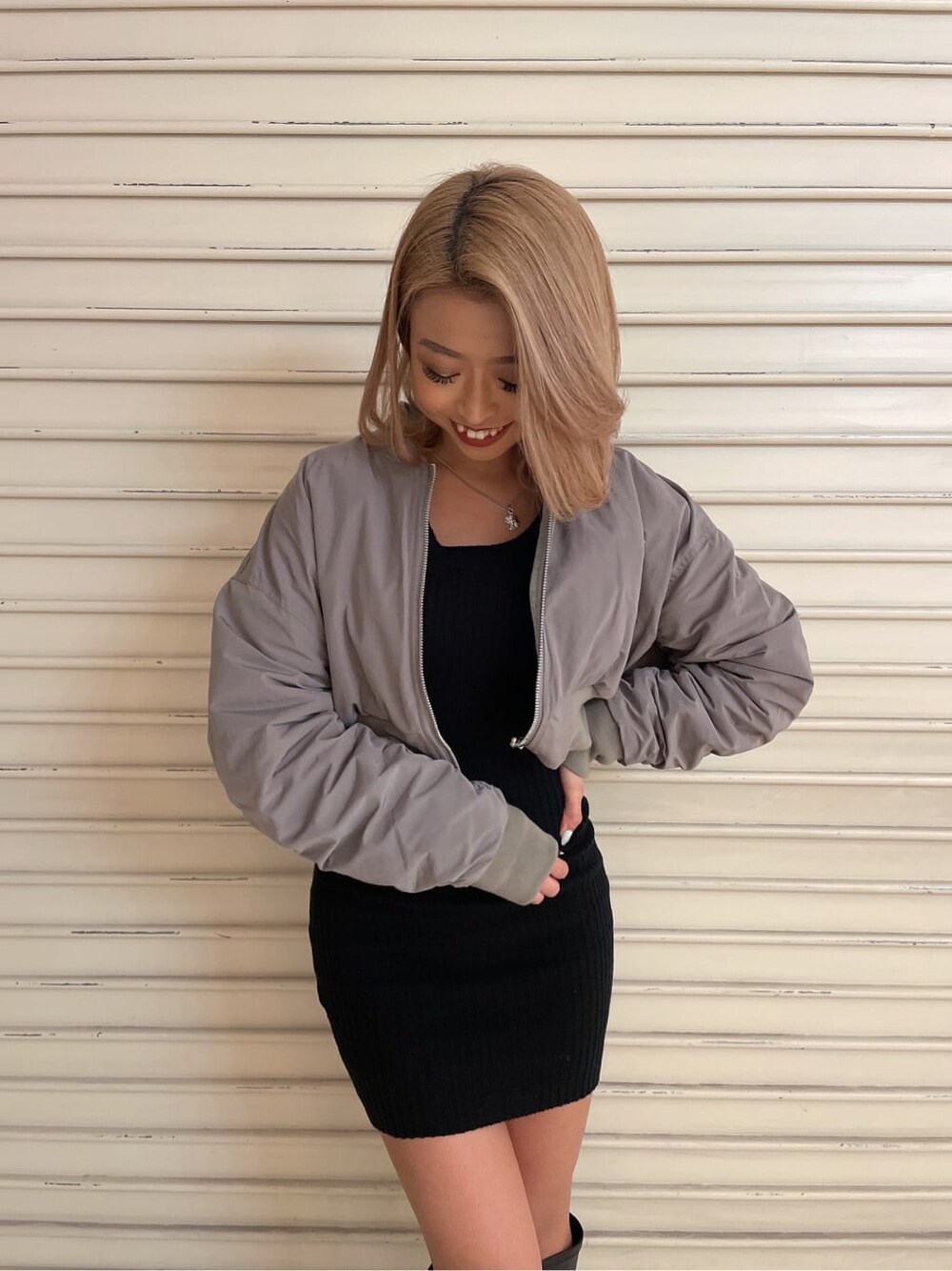 ブラック系のブーツ、グレー系のMA-1、ブラック系のワンピースを着用したレディースの冬コーディネートの3枚目の写真