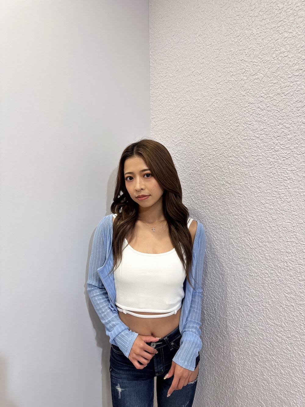 ホワイト系のキャミソール、ブルー系のカーディガン/ボレロ、ブルー系のデニムパンツを着用したレディースの夏コーディネートの5枚目の写真