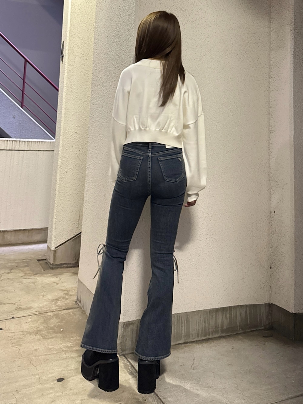 ホワイト系のニット/セーター、ブルー系のデニムパンツ、ブラック系のブーツを着用したレディースの秋コーディネートの3枚目の写真