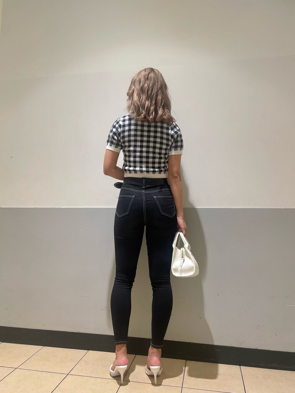ホワイト系のハンドバッグ、ブラック系のデニムパンツ、ブラック系のカーディガン/ボレロを着用したレディースの春コーディネートの3枚目の写真