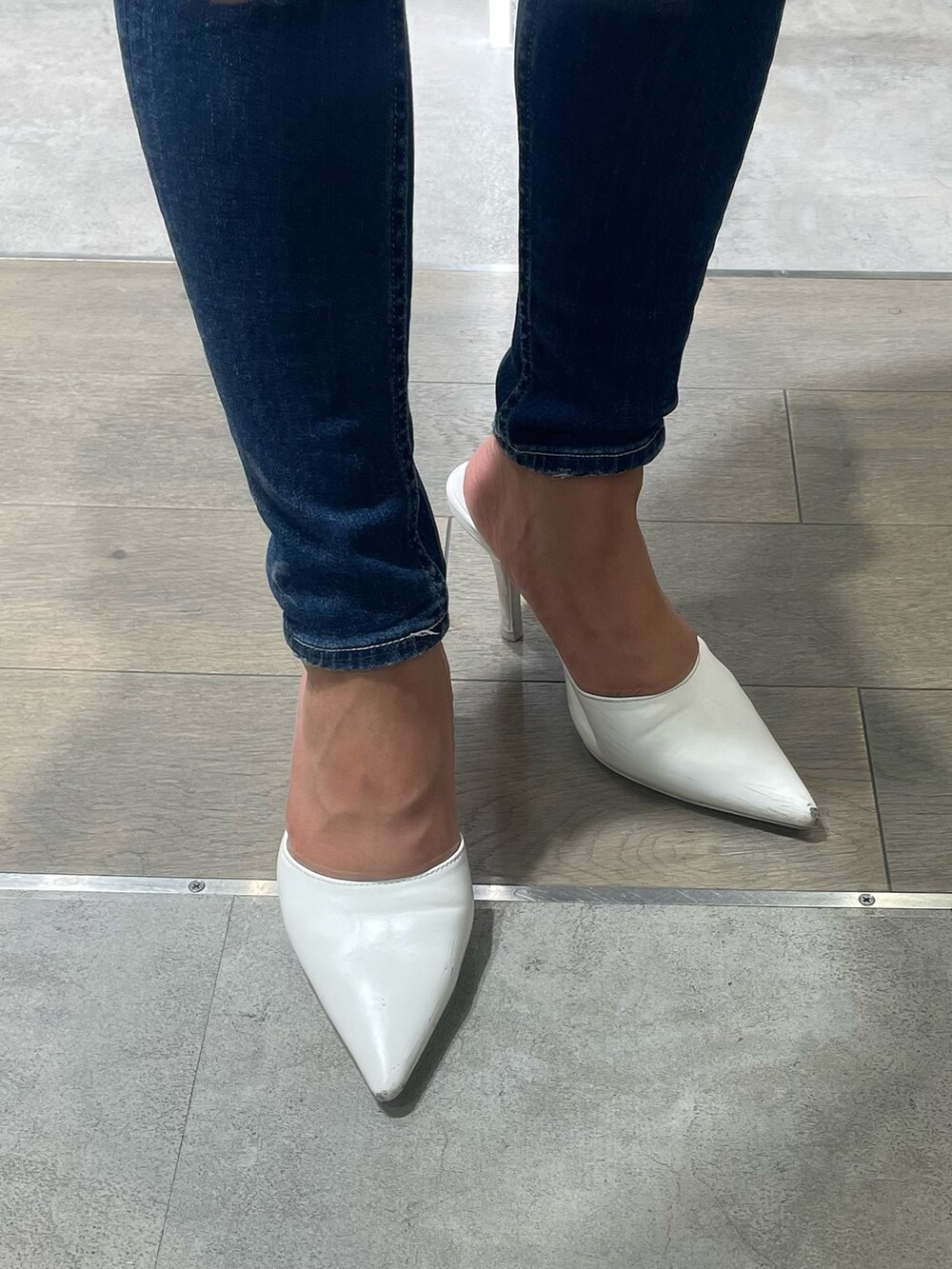 ブルー系のニット/セーター、ブルー系のデニムパンツ、ホワイト系のパンプスを着用したレディースの冬コーディネートの8枚目の写真