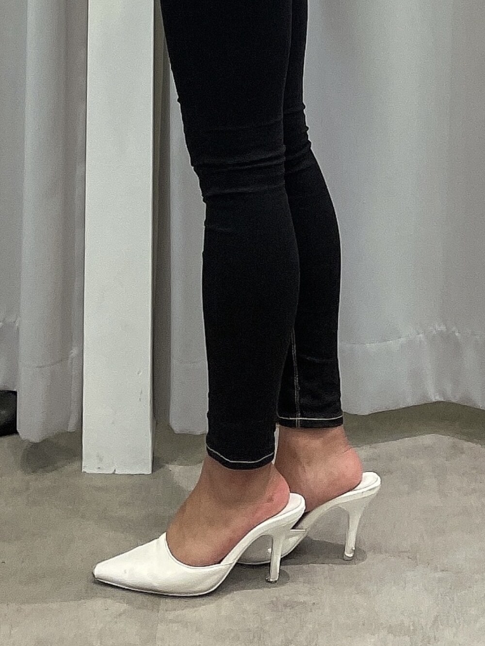 ブラック系のニット/セーター、ブラック系のデニムパンツ、ホワイト系のパンプスを着用したレディースの夏コーディネートの8枚目の写真