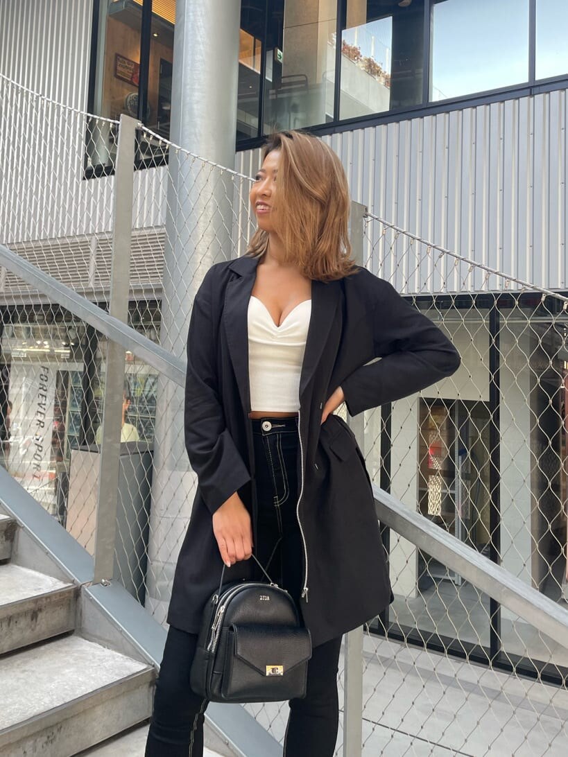 ホワイト系のチューブトップ、ブラック系のパンプス、ブラック系のデニムパンツを着用したレディースの春コーディネートの9枚目の写真