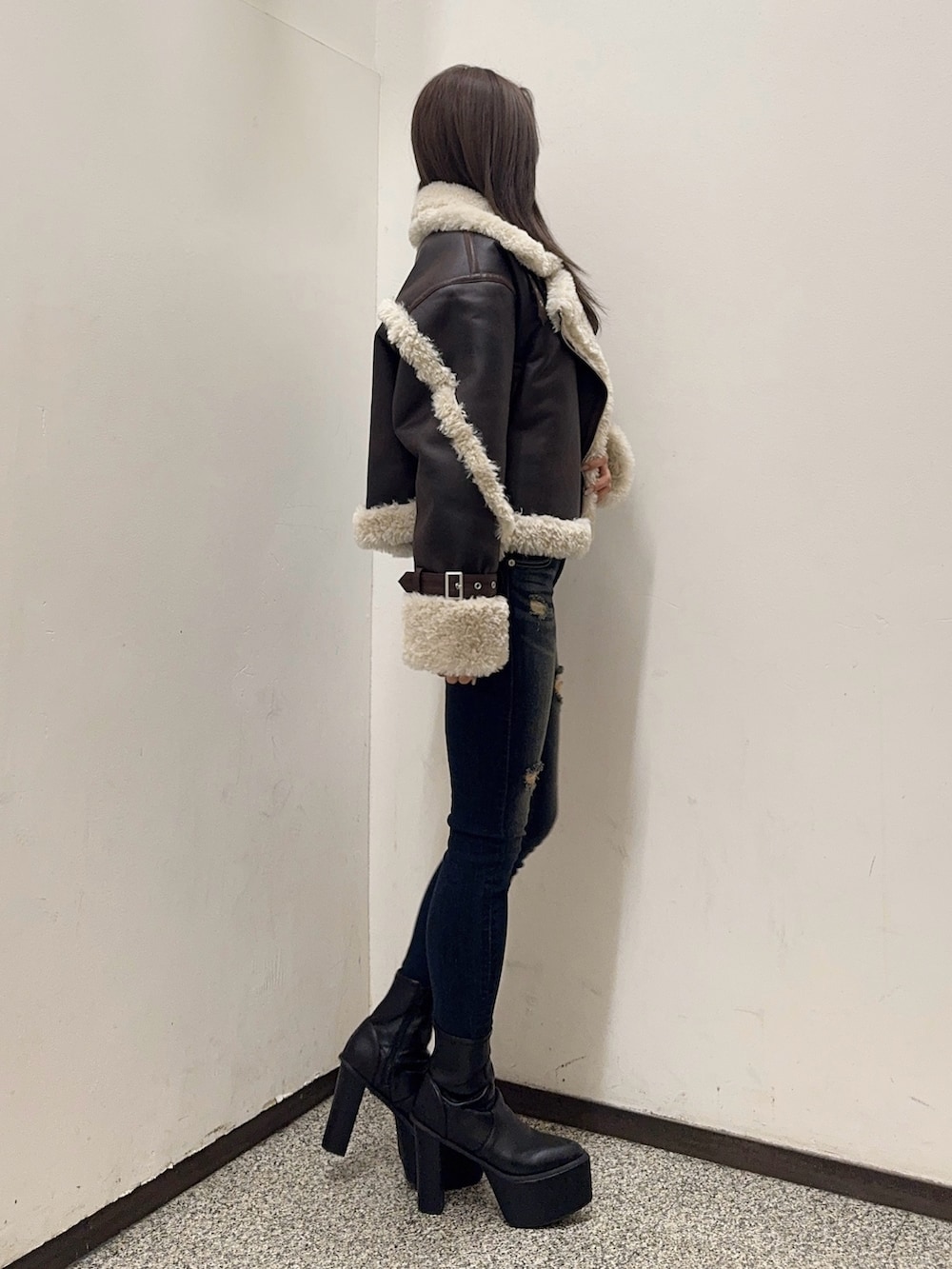 ホワイト系のTシャツ/カットソー、ブラウン系のムートンコート、ブルー系のデニムパンツを着用したレディースの秋コーディネートの3枚目の写真