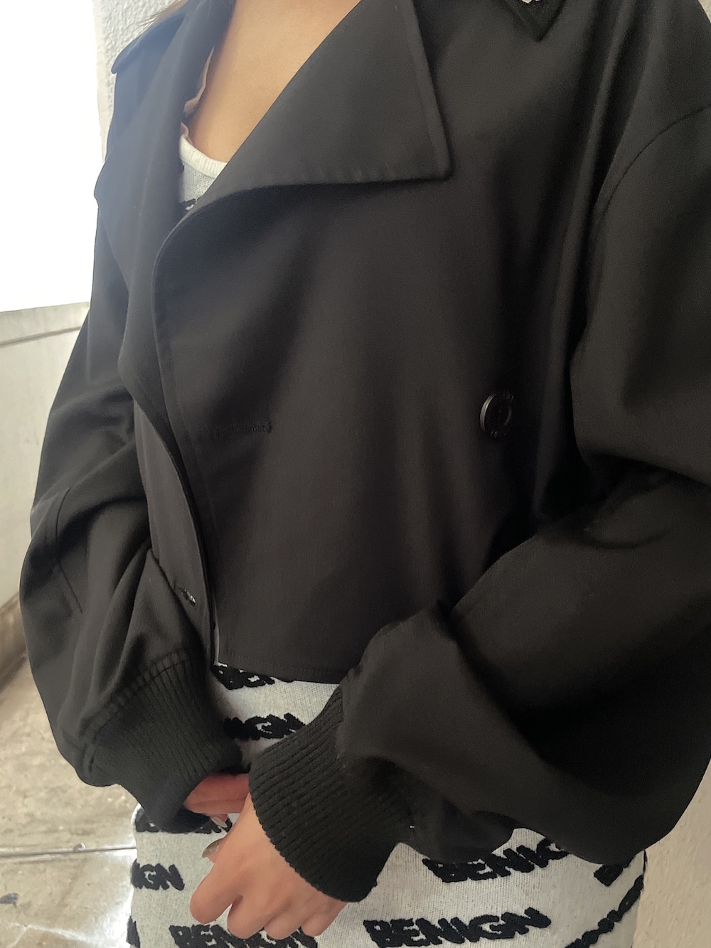 ホワイト系のワンピース、ブラック系のブルゾン、ブラック系のブーツを着用したレディースの夏コーディネートの7枚目の写真