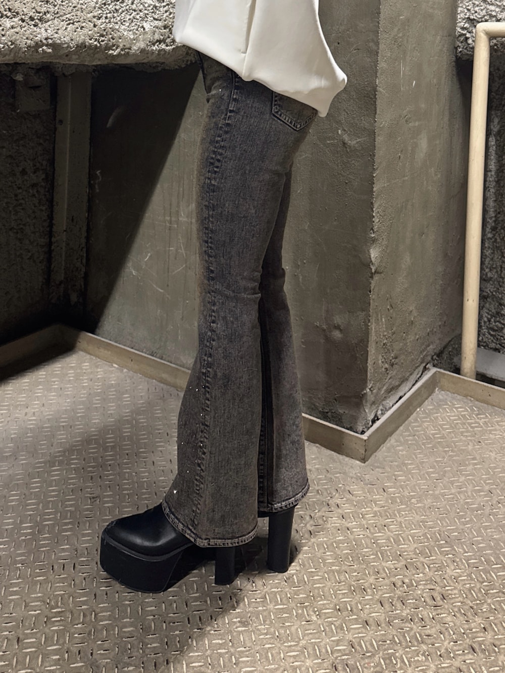 ホワイト系のスウェット、ブルー系のデニムパンツ、ブラック系のブーツを着用したレディースの冬コーディネートの8枚目の写真