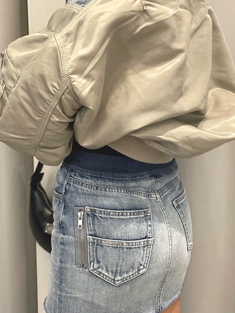 ブルー系のデニムジャケット、ブルー系のデニムスカート、ブラック系のチューブトップを着用したレディースの冬コーディネートの9枚目の写真