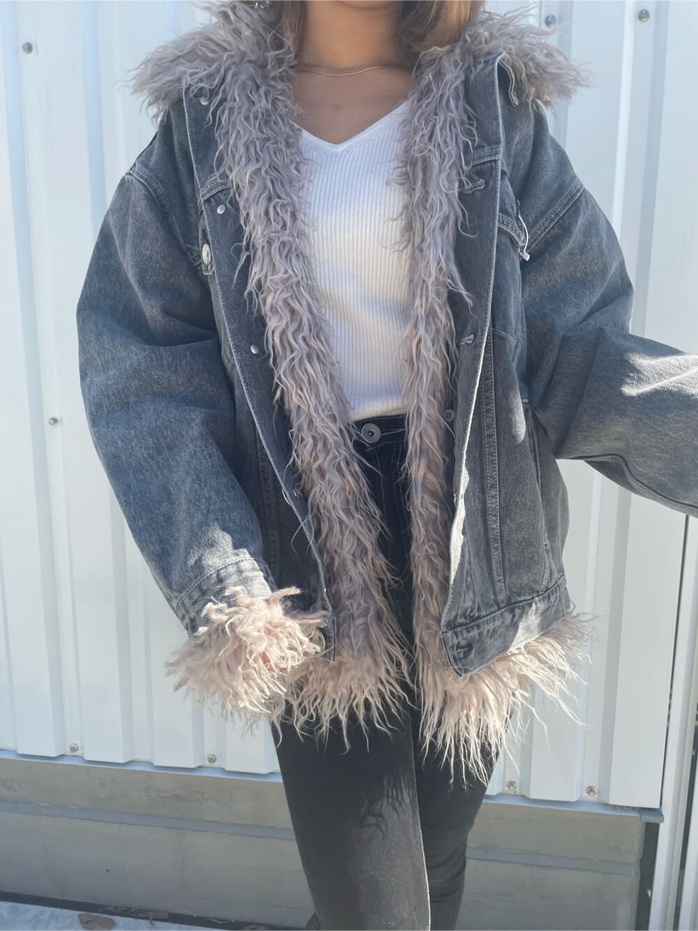 ブラック系のブーツ、ブラック系のデニムパンツ、ホワイト系のニット/セーターを着用したレディースの秋コーディネートの5枚目の写真