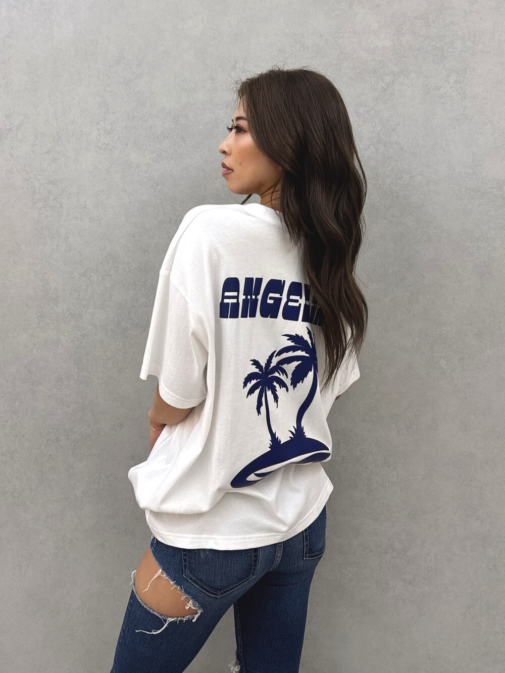 ホワイト系のTシャツ/カットソー、ブルー系のデニムパンツ、ホワイト系のパンプスを着用したレディースの春コーディネートの5枚目の写真