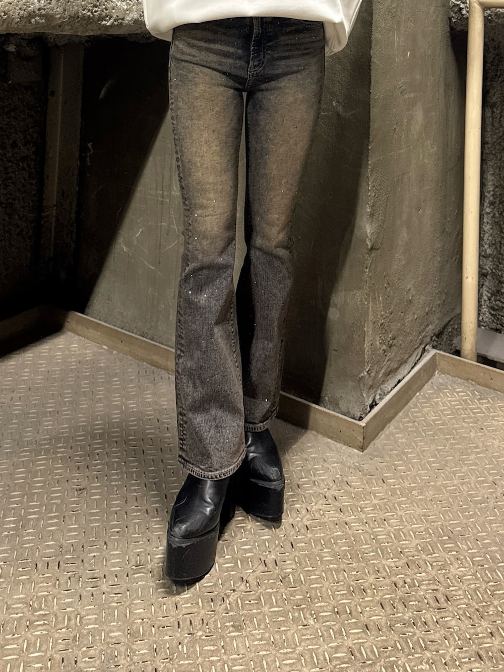 ホワイト系のスウェット、ブルー系のデニムパンツ、ブラック系のブーツを着用したレディースの冬コーディネートの7枚目の写真