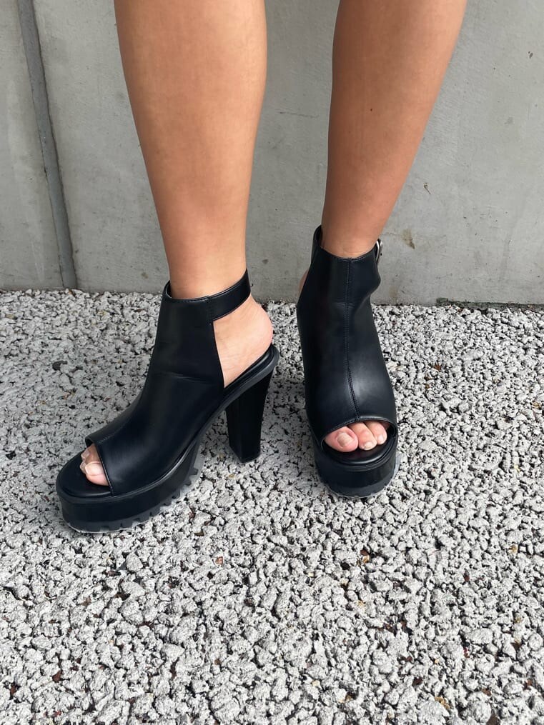 ブラック系のワンピース、ブラック系のブーツを着用したレディースの春コーディネートの8枚目の写真