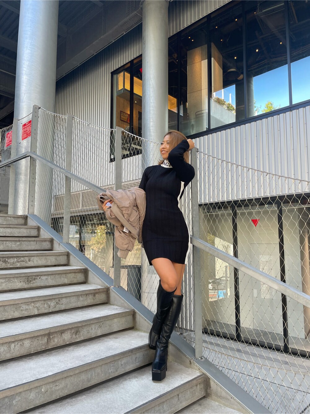 ベージュ系のMA-1、ブラック系のワンピース、ブラック系のブーツを着用したレディースの秋コーディネートの3枚目の写真