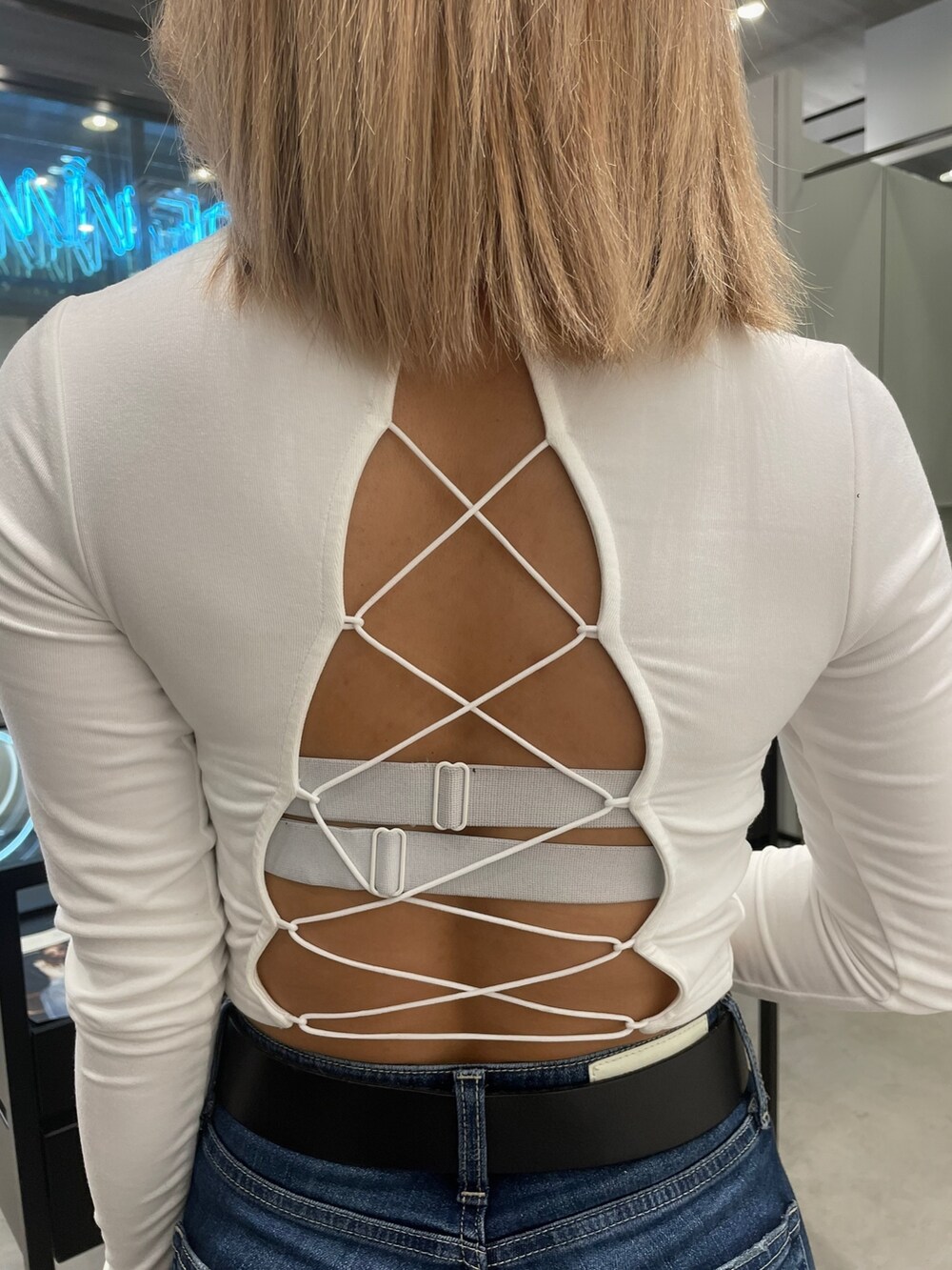 ホワイト系のTシャツ/カットソー、ホワイト系のチューブトップ、ブルー系のデニムパンツを着用したレディースの冬コーディネートの4枚目の写真