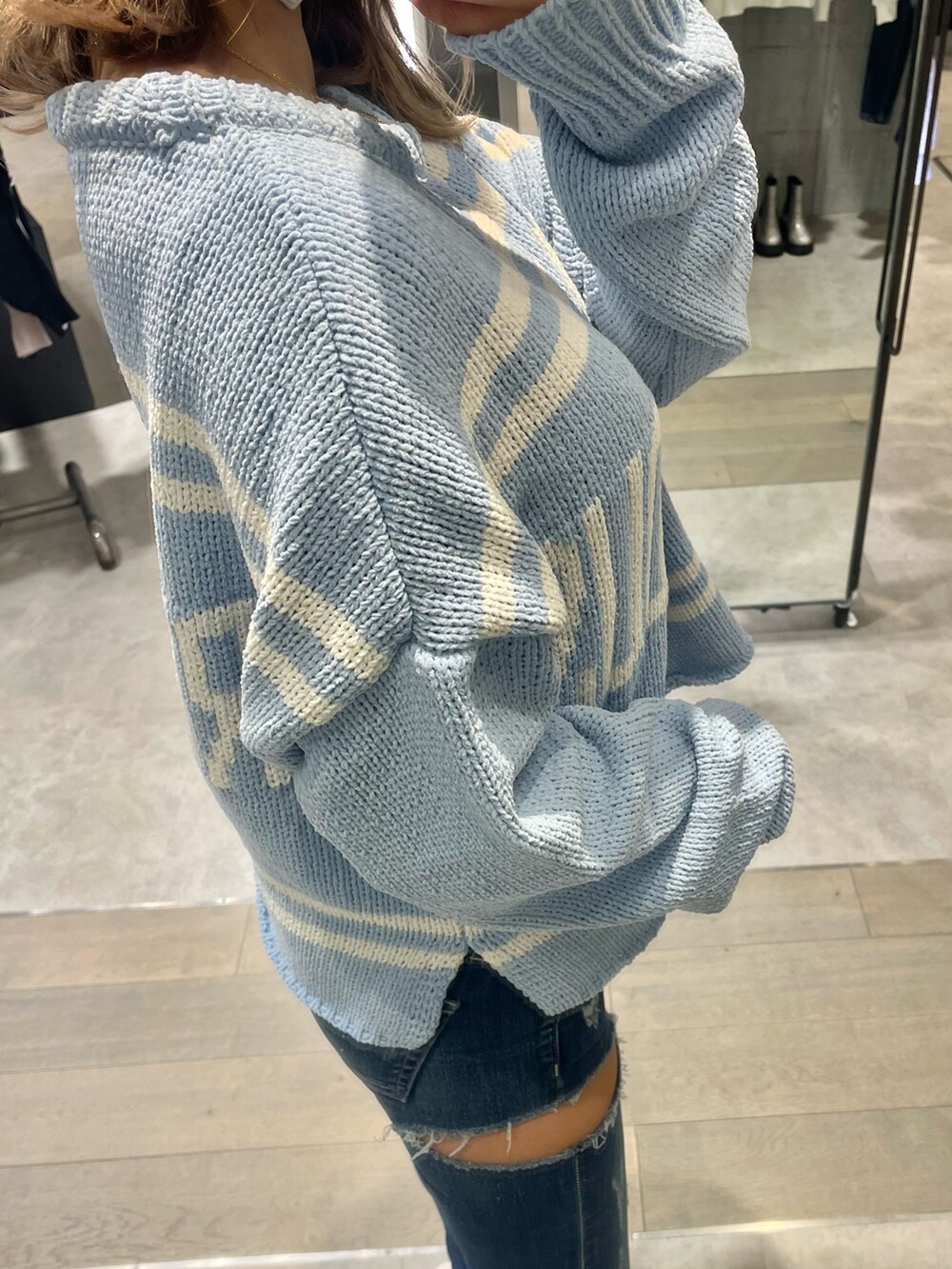 ブルー系のニット/セーター、ブルー系のデニムパンツ、ホワイト系のパンプスを着用したレディースの冬コーディネートの5枚目の写真