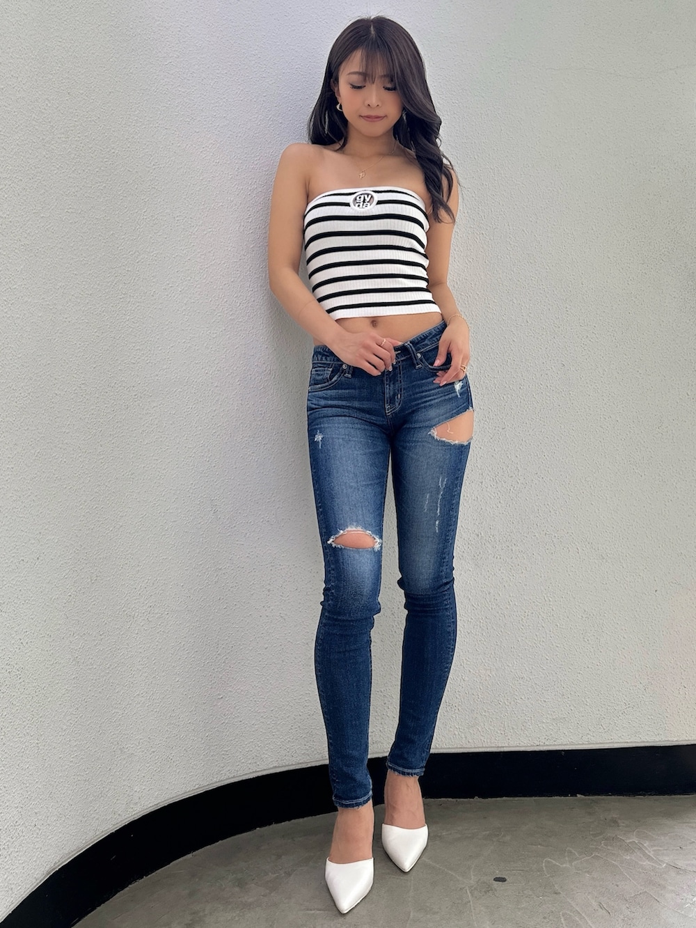 その他のチューブトップ、ブルー系のデニムパンツ、ホワイト系のパンプスを着用したレディースの春コーディネートの2枚目の写真