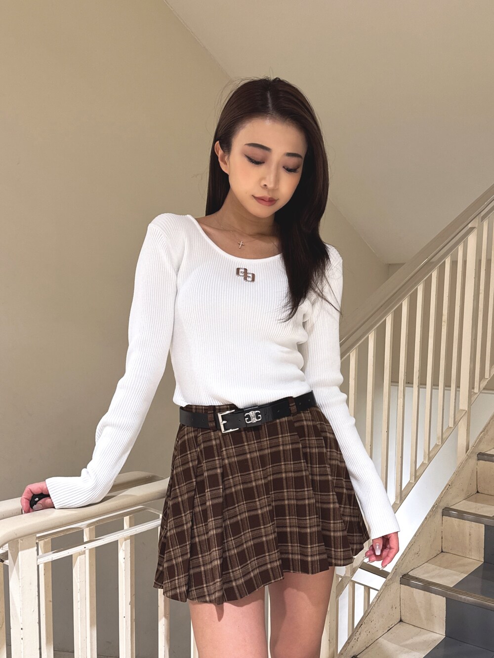 ホワイト系のニット/セーター、ブラウン系のスカート、ベージュ系のブーツを着用したレディースの秋コーディネートの4枚目の写真