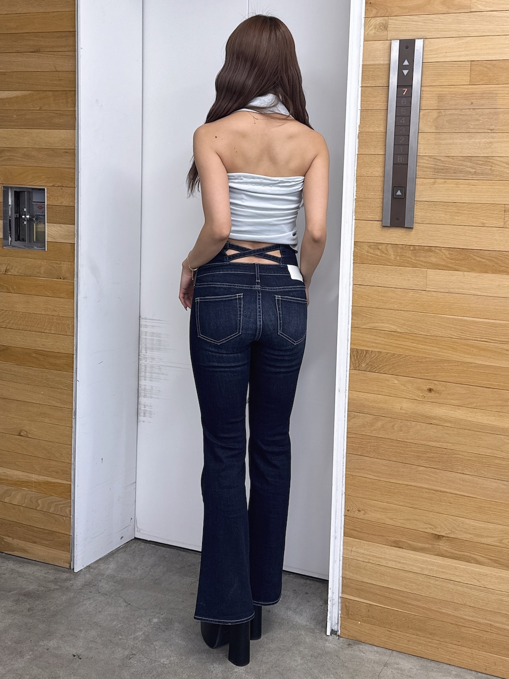 ブルー系のチューブトップ、ブルー系のデニムパンツ、ブラック系のサンダルを着用したレディースの春コーディネートの3枚目の写真