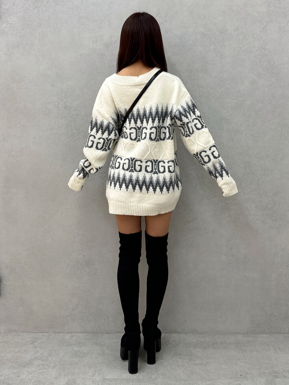 ホワイト系のニット/セーター、ブラック系のハンドバッグ、ブラック系のブーツを着用したレディースの冬コーディネートの4枚目の写真