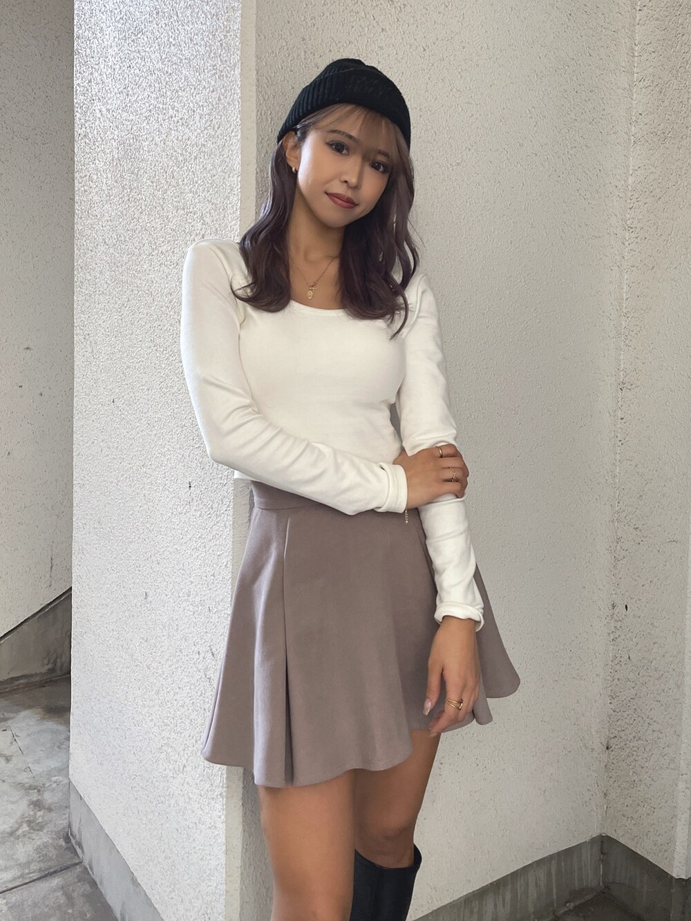 ベージュ系のブルゾン、ベージュ系のスカート、ホワイト系のTシャツ/カットソーを着用したレディースの冬コーディネートの6枚目の写真