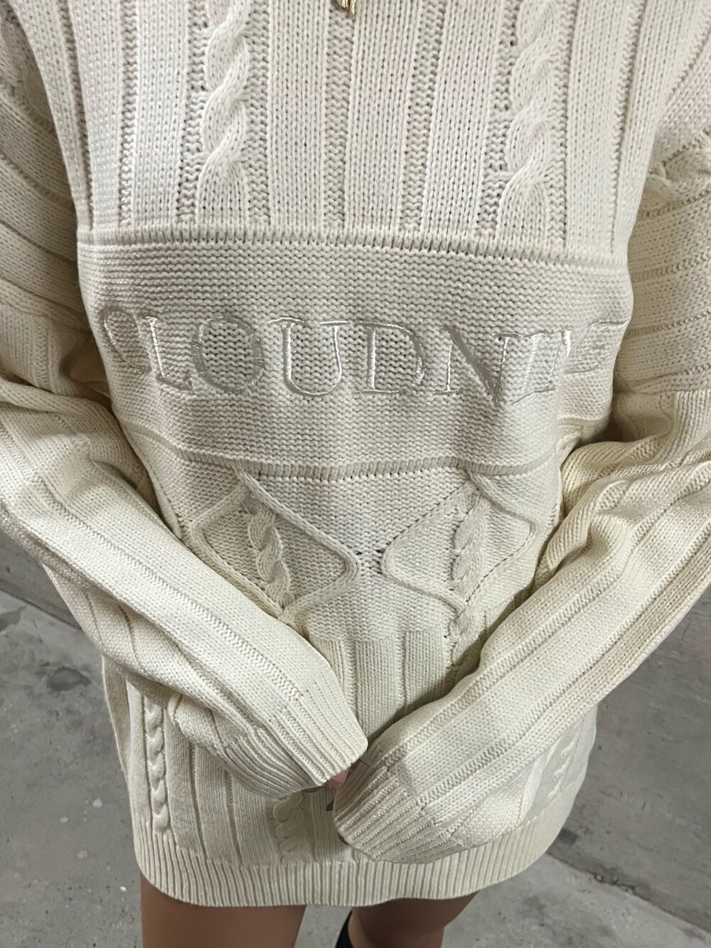 グリーン系のニット/セーター、ホワイト系のニット/セーター、ブラック系のブーツを着用したレディースの秋コーディネートの6枚目の写真