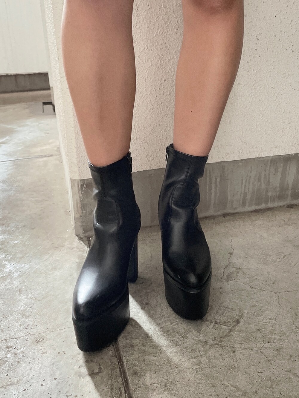 ホワイト系のワンピース、ブラック系のブルゾン、ブラック系のブーツを着用したレディースの夏コーディネートの8枚目の写真