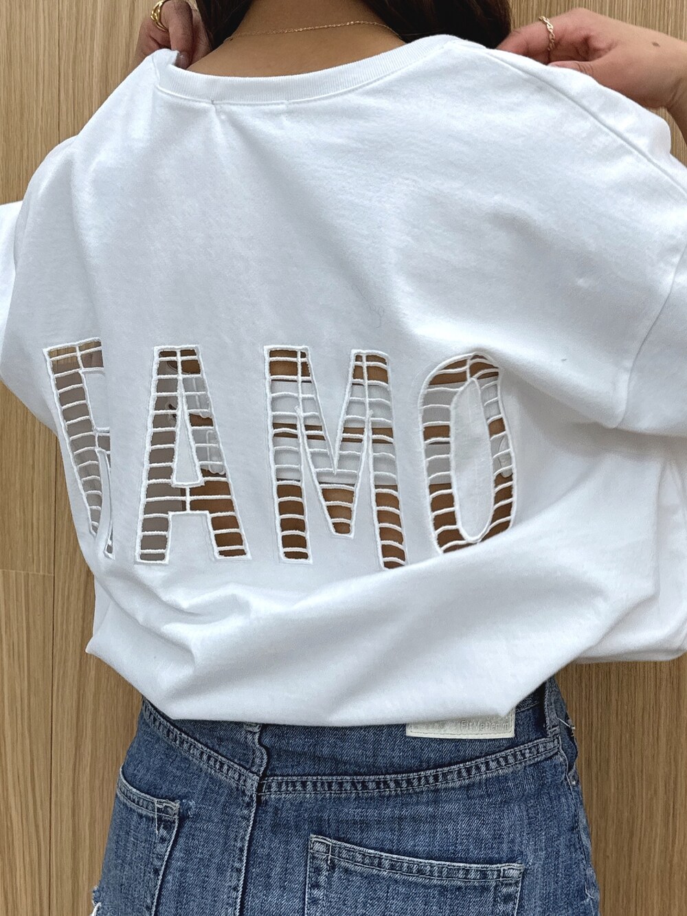 ホワイト系のTシャツ/カットソー、ブルー系のデニムスカート、ブラック系のブーツを着用したレディースの春コーディネートの7枚目の写真