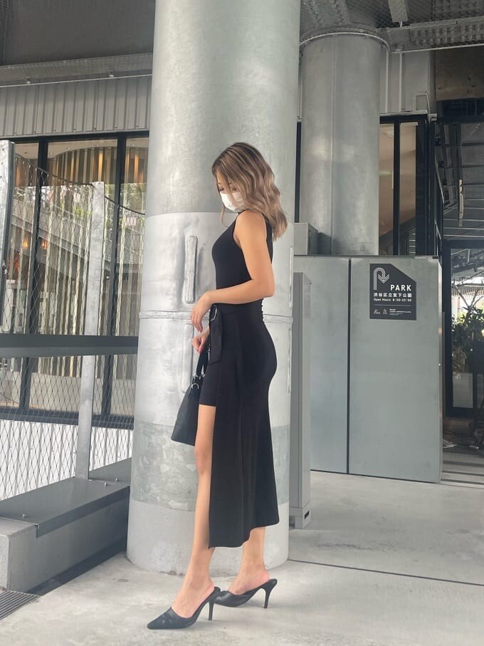 ブラック系のパンプス、ブラック系のワンピース、ブラック系のハンドバッグを着用したレディースの夏コーディネートの2枚目の写真