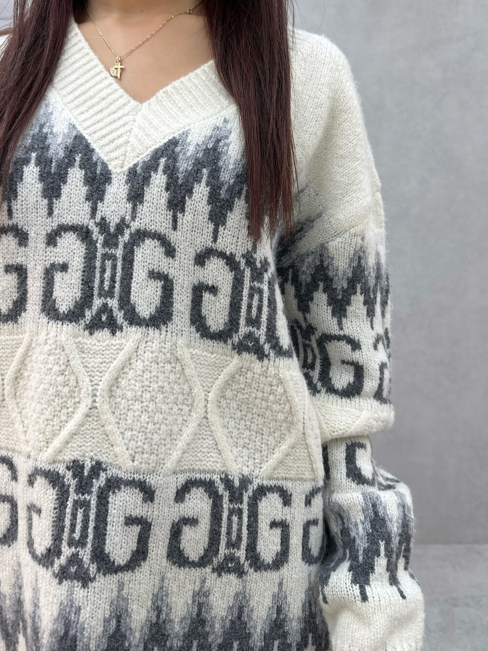 ホワイト系のニット/セーター、ブラック系のハンドバッグ、ブラック系のブーツを着用したレディースの冬コーディネートの6枚目の写真