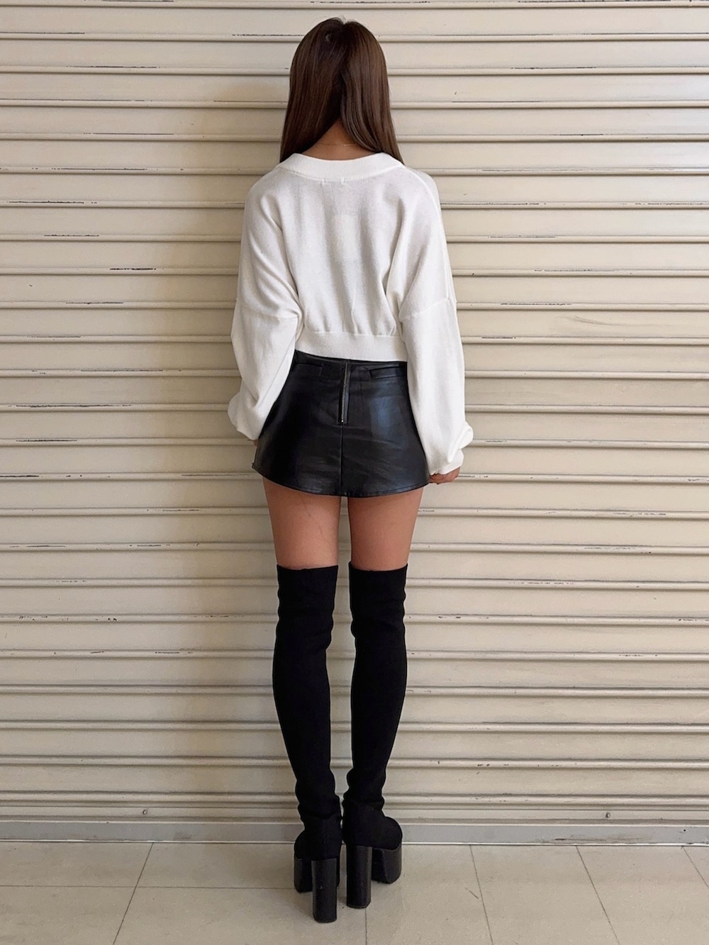 ホワイト系のニット/セーター、ブラック系のスカート、ブラック系のブーツを着用したレディースの秋コーディネートの4枚目の写真