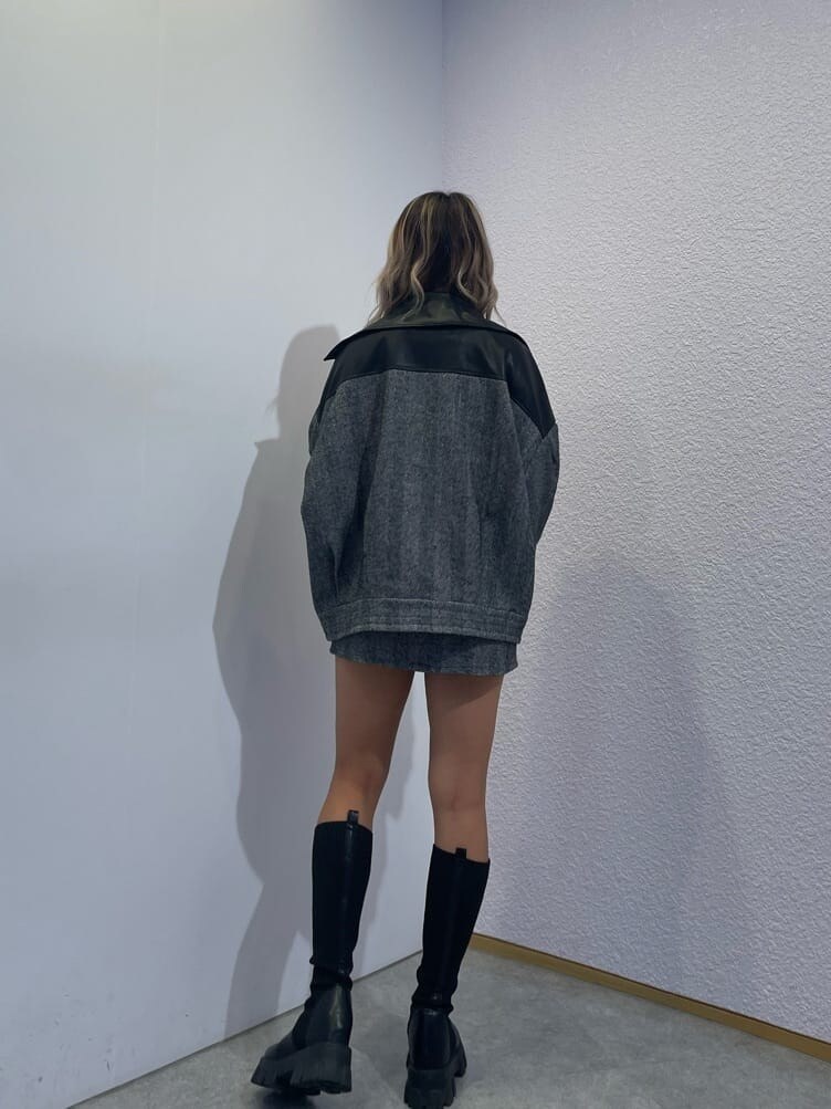 ブラック系のライダースジャケット、ブラック系のニット/セーター、ブラック系のスカートを着用したレディースの秋コーディネートの2枚目の写真