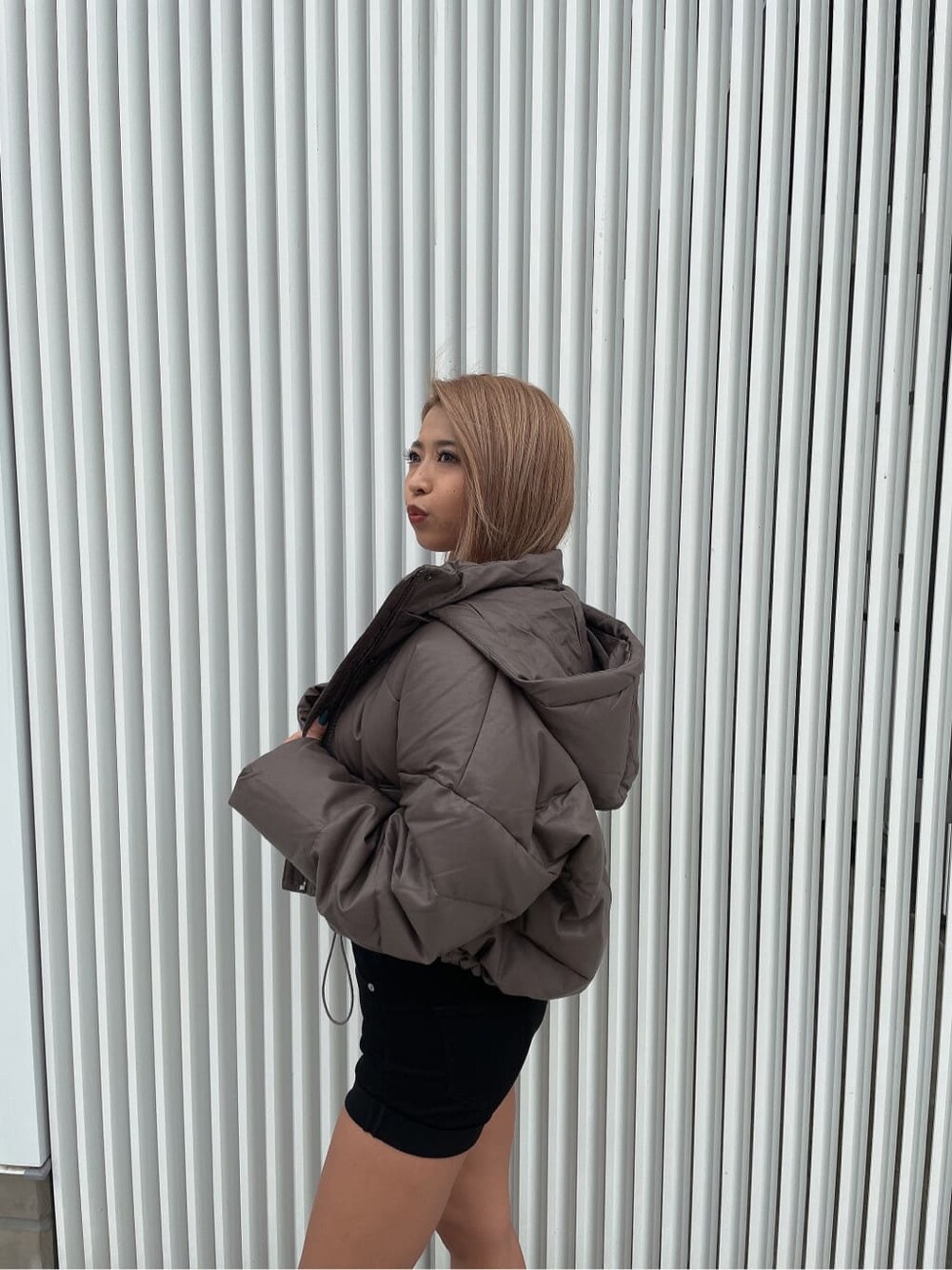 ベージュ系のダウンジャケット/コート、ブラック系のデニムパンツ、ブラック系のブーツを着用したレディースの秋コーディネートの7枚目の写真