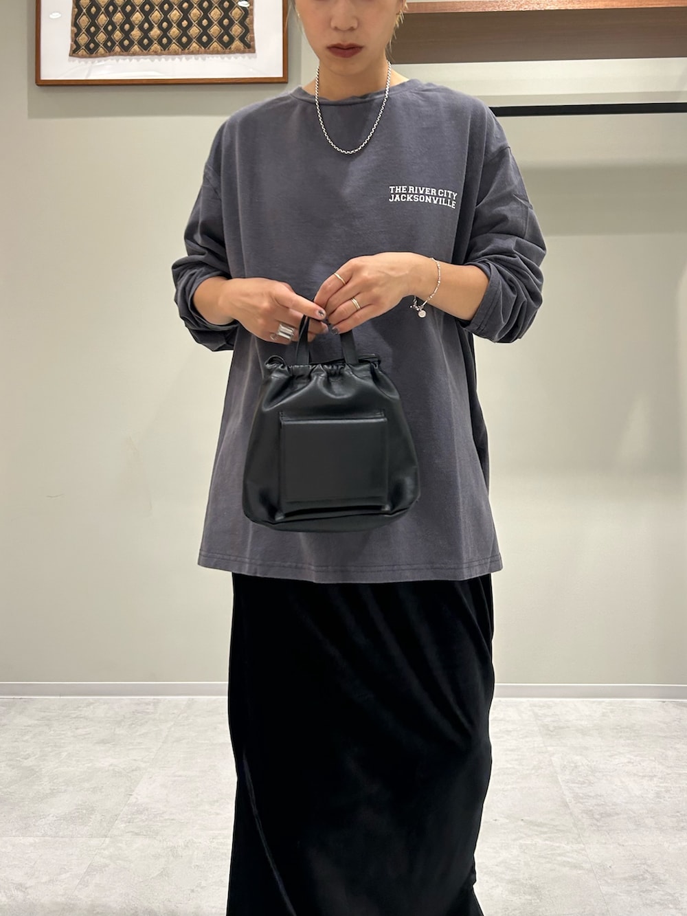 グレー系のテーラードジャケット、ブルー系のTシャツ/カットソー、ブラック系のスカートを着用したレディースの秋コーディネートの7枚目の写真