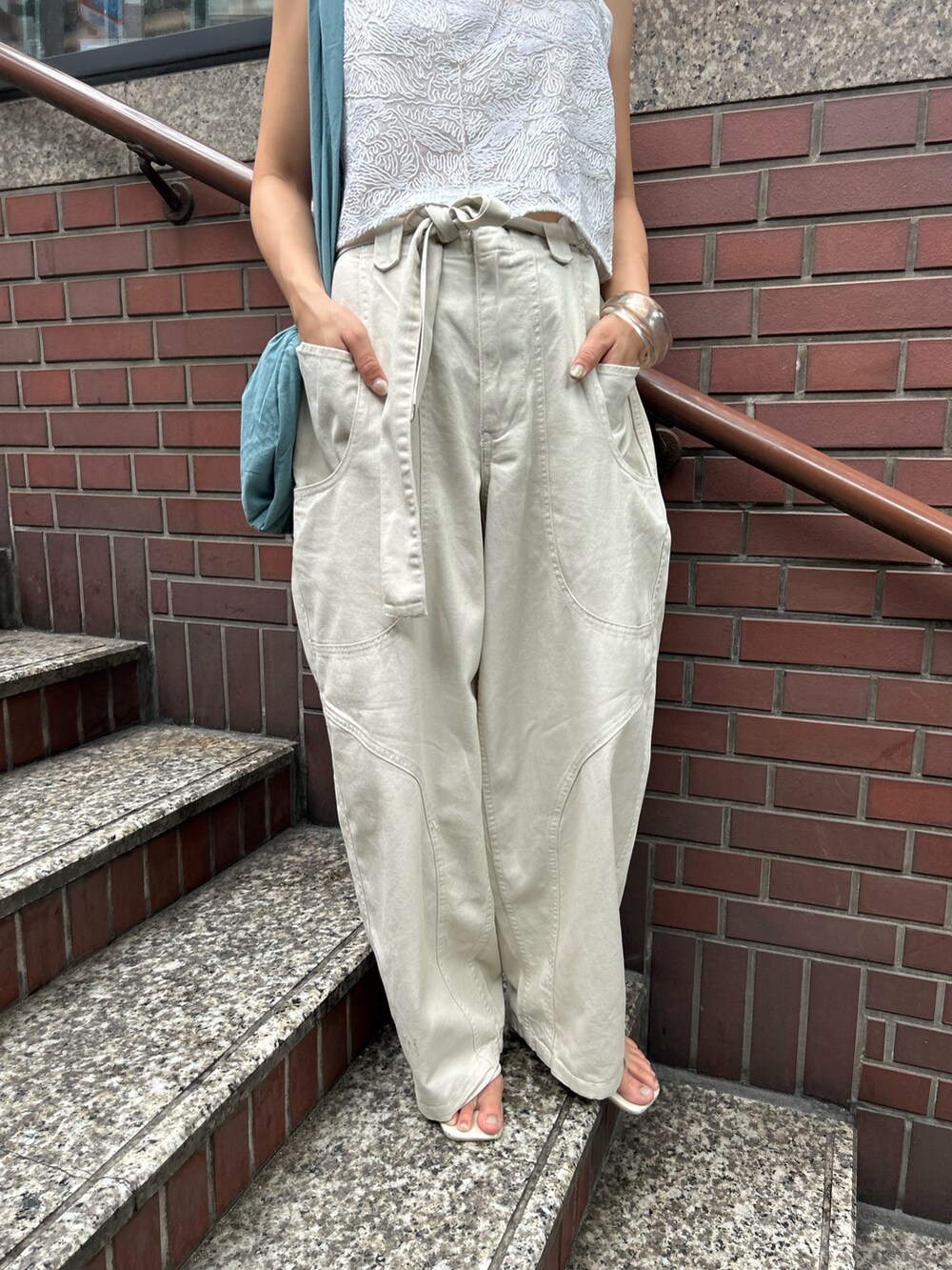 ホワイト系のその他パンツ、ホワイト系のキャミソール、ブルー系のトートバッグを着用したレディースの夏コーディネートの9枚目の写真