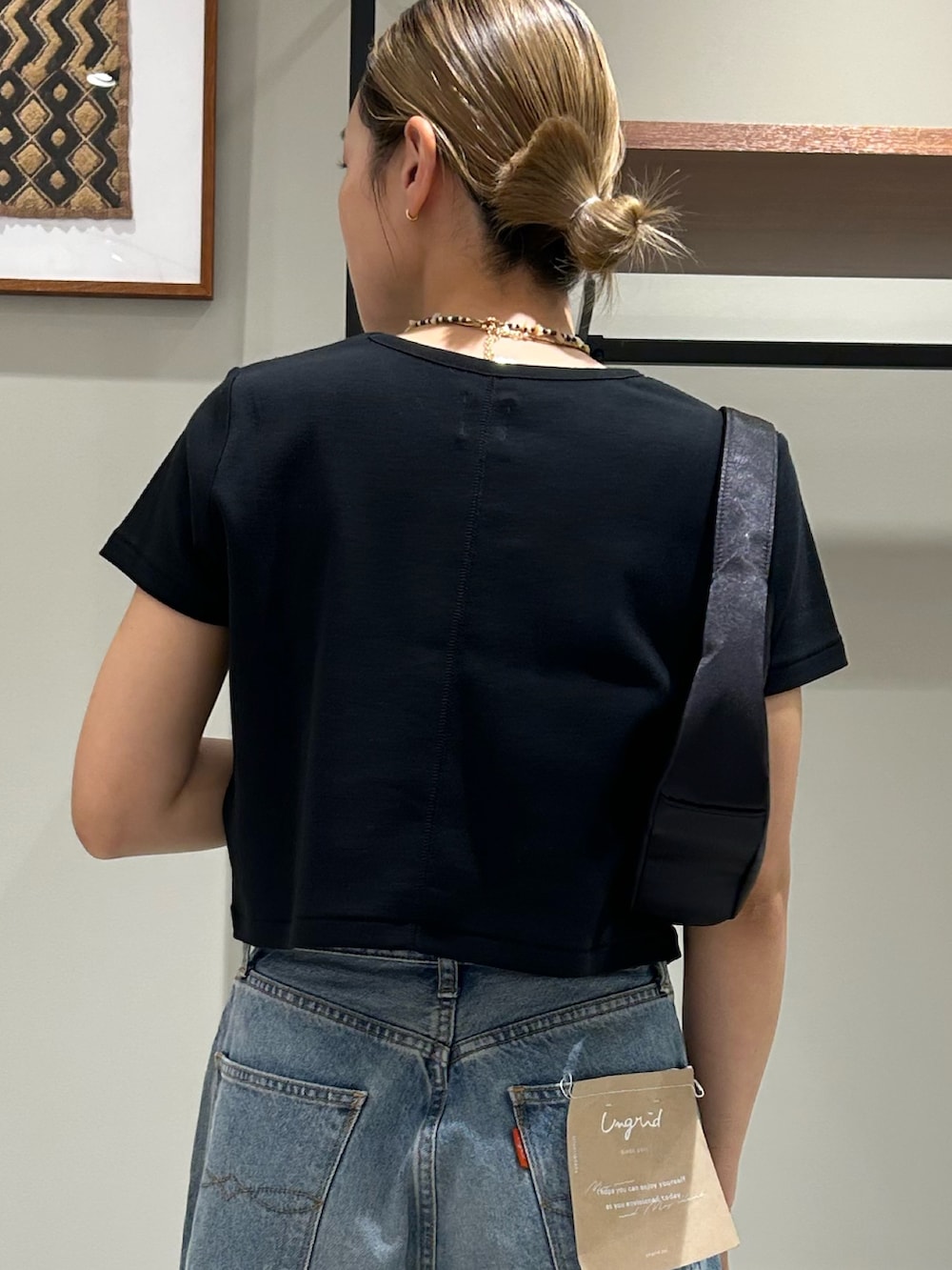 ホワイト系のサンダル、ブラック系のTシャツ/カットソー、ブラック系のハンドバッグを着用したレディースの夏コーディネートの6枚目の写真