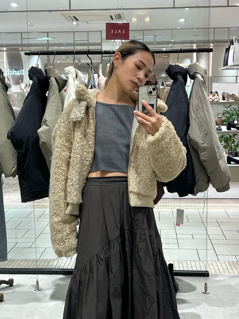 ホワイト系のブルゾン、グレー系のスカート、グレー系のニット/セーターを着用したレディースの冬コーディネートの4枚目の写真